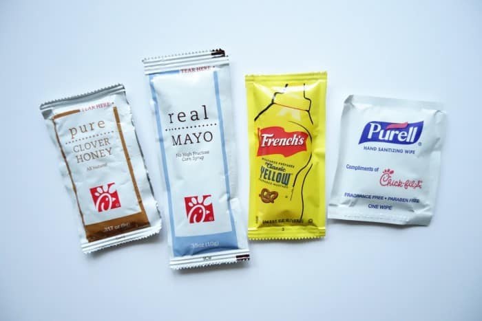 Individual condiment packets of honey, mayo, and mustard